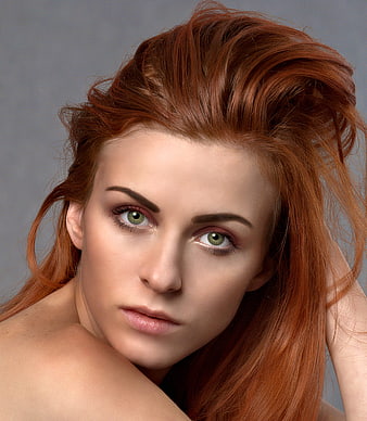 Close-up portrait of beautiful red-haired woman with green eyes