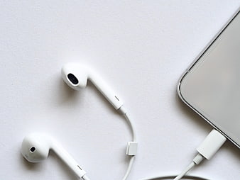 White wired earphones and smartphone on white background