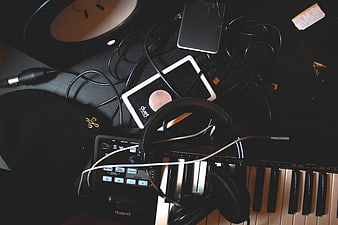 Music production setup with keyboard, headphones, and tablet