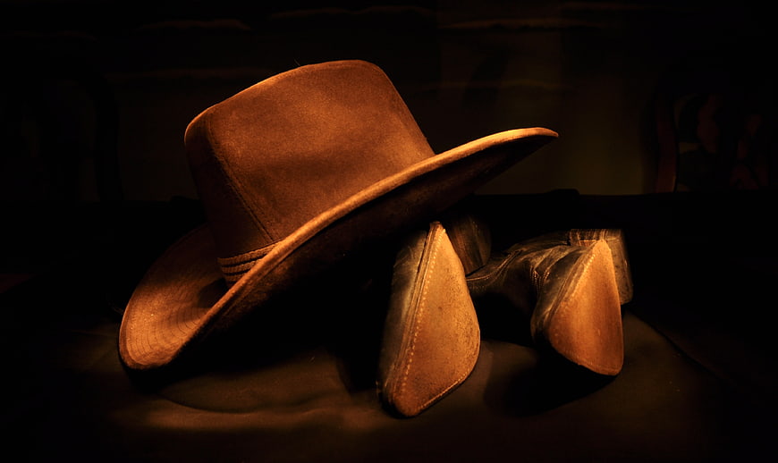 Vintage Cowboy Hat and Boots in Dramatic Warm Lighting