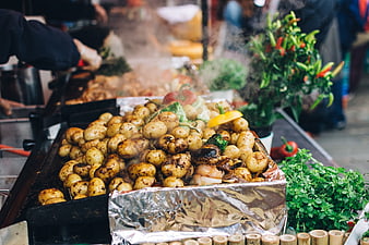 Steaming roasted potatoes and vegetables at a street food market