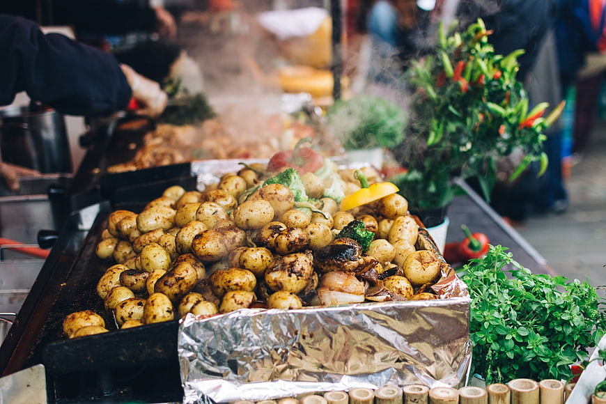 Steaming roasted potatoes and vegetables at a street food market