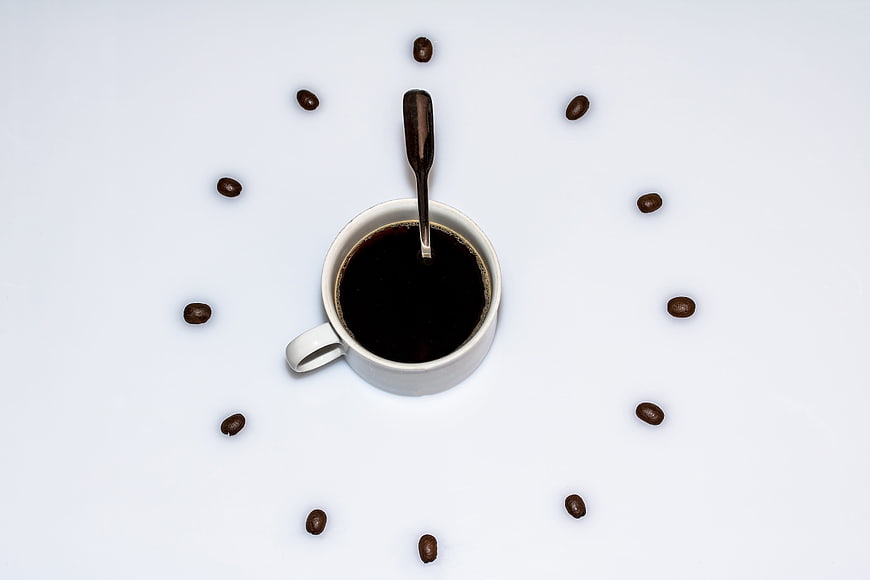Top view coffee cup clock with beans on white background