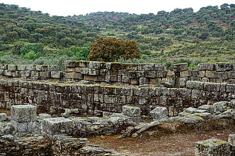 Ancient stone ruins with mossy walls and green hills
