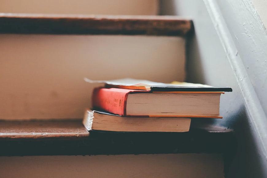 Stack of Books on Wooden Staircase Steps