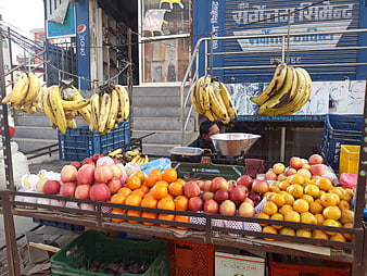 Street fruit vendor selling bananas, apples, and oranges in Nepal