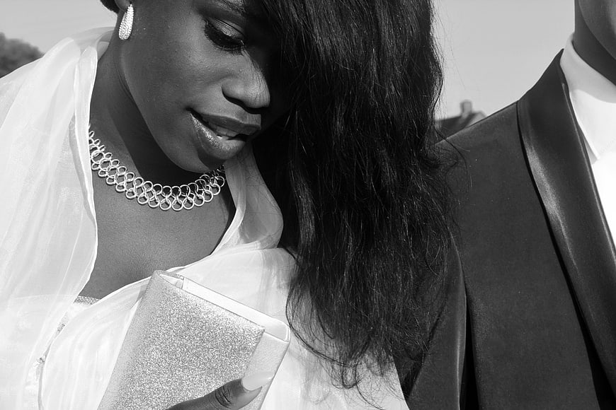 Black and white portrait of bride and groom holding clutch