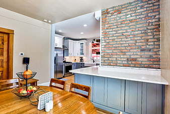 Modern kitchen with exposed brick wall and dining table