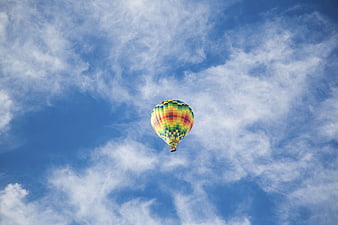 Colorful Hot Air Balloon Flying in Blue Sky with Clouds