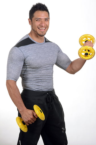 Smiling Fit Man Lifting Yellow Dumbbells In Studio