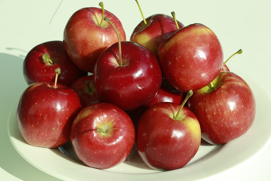 Fresh Red Apples Piled on a White Plate