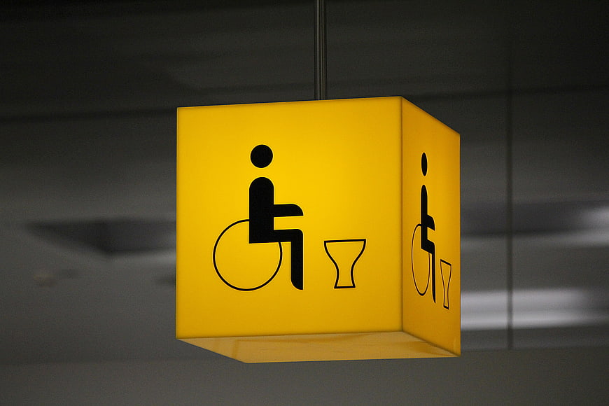 Yellow Hanging Accessible Toilet Sign with Wheelchair Icon