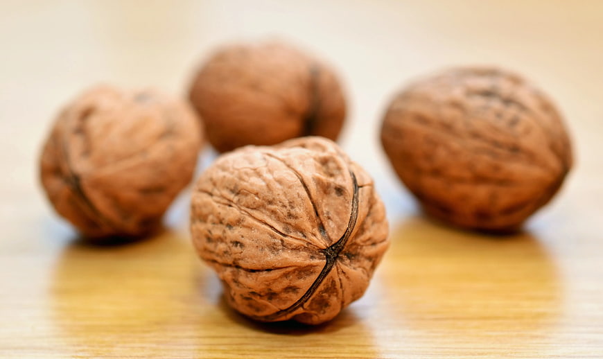 Whole Walnuts on Wooden Table Surface