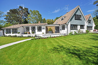 Modern White House with Green Lawn and Blue Sky