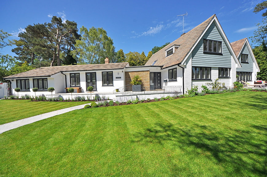 Modern White House with Green Lawn and Blue Sky