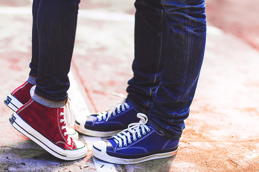 Couple Wearing Red and Blue Sneakers Standing Together