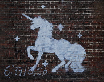 White Unicorn Street Art Stencil On Dark Red Brick Wall