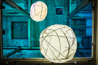 Glowing spherical lanterns in industrial blue warehouse interior