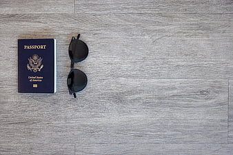 US Passport and Sunglasses on Wooden Surface with Copyspace