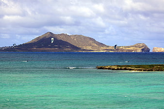 Kitesurfers in Turquoise Water with Volcanic Island Landscape