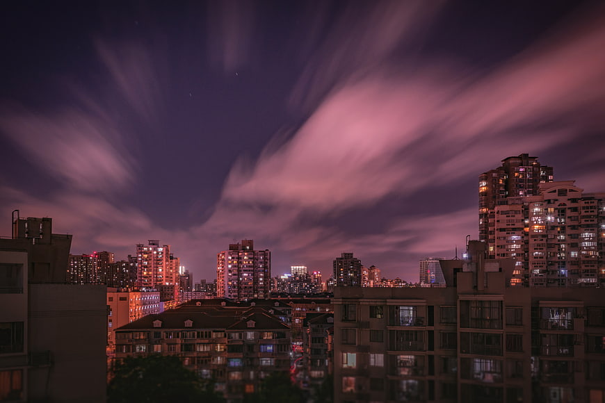 Dramatic purple clouds over city skyline at night