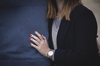 Close-up of couple embracing with red nails and watch