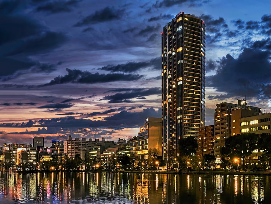 Modern high-rise apartment skyline at dusk with river reflections