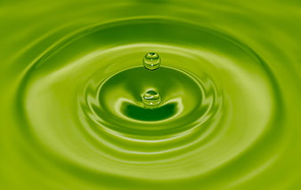 Green liquid splash with water droplets and ripples