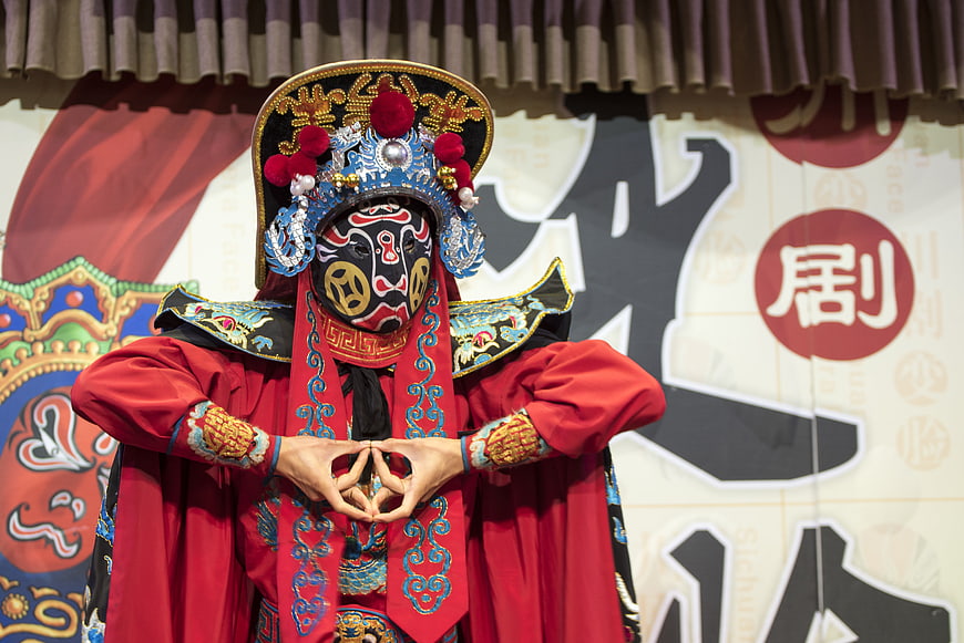 Sichuan Opera Performer in Traditional Mask and Costume