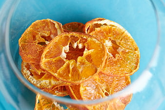 Dried Orange Slices in Glass Bowl on Blue Background