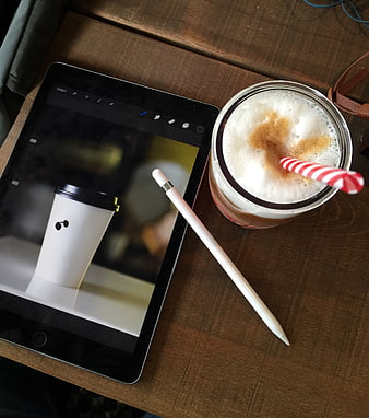 Top view of tablet with stylus and iced coffee on wooden table