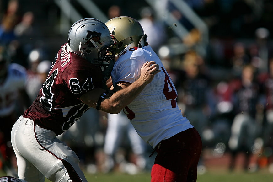 American Football Players Tackling on Field