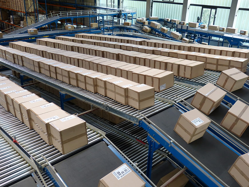 Cardboard boxes moving on conveyor belts in a logistics warehouse