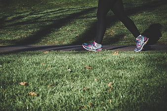 Runner's legs and colorful sneakers on a park path
