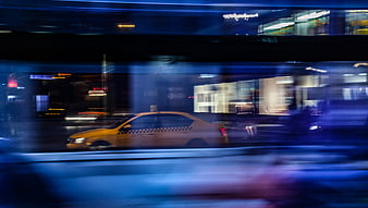 Yellow taxi speeding through city at night with motion blur