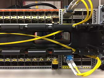 Close-up of network switch ports with yellow fiber optic cables