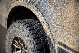 Close-up of muddy off-road tire and wheel on SUV
