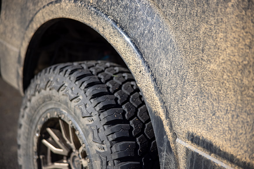Close-up of muddy off-road tire and wheel on SUV