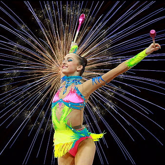 Rhythmic gymnast performing with batons and fireworks background