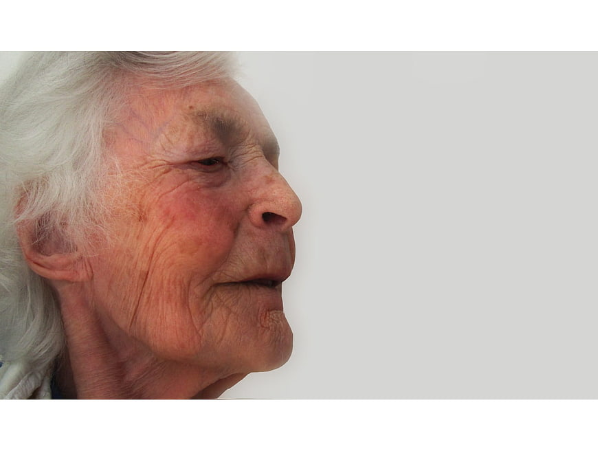 Close-up profile portrait of an elderly woman with white hair