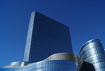 Modern Glass Skyscraper And Curved Architecture Against Clear Blue Sky