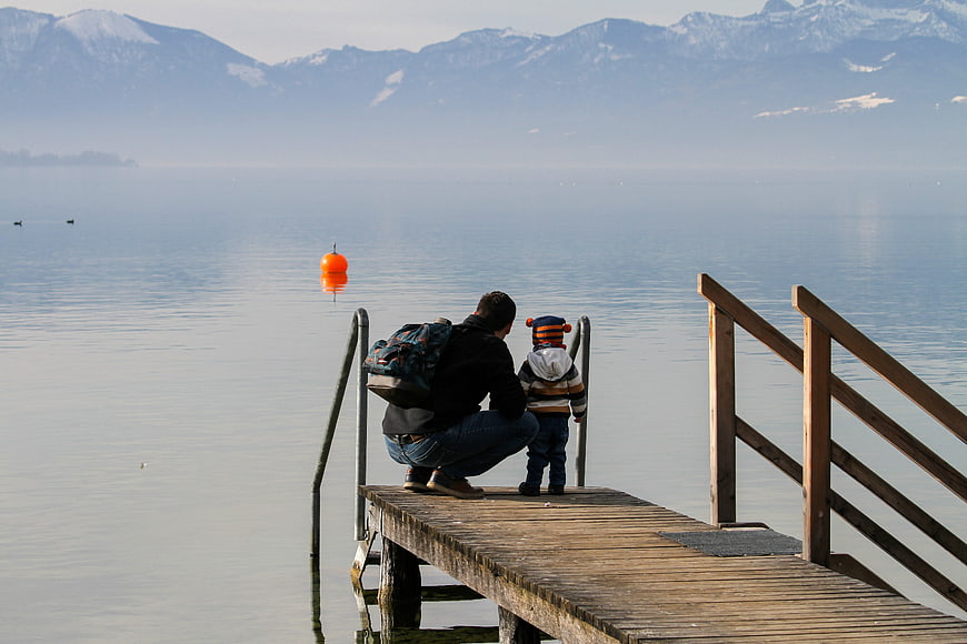 Father and Child on Wooden Dock at Misty Lake