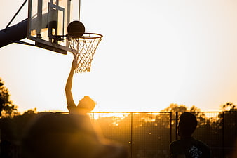 Silhouette of Basketball Player Dunking at Sunset