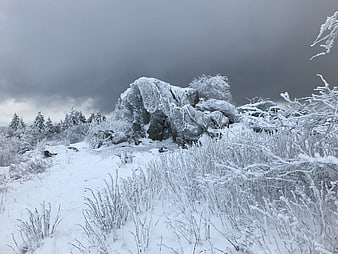 Frozen winter landscape with icy rocks and snow-covered trees
