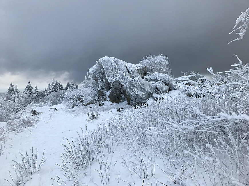 Frozen winter landscape with icy rocks and snow-covered trees