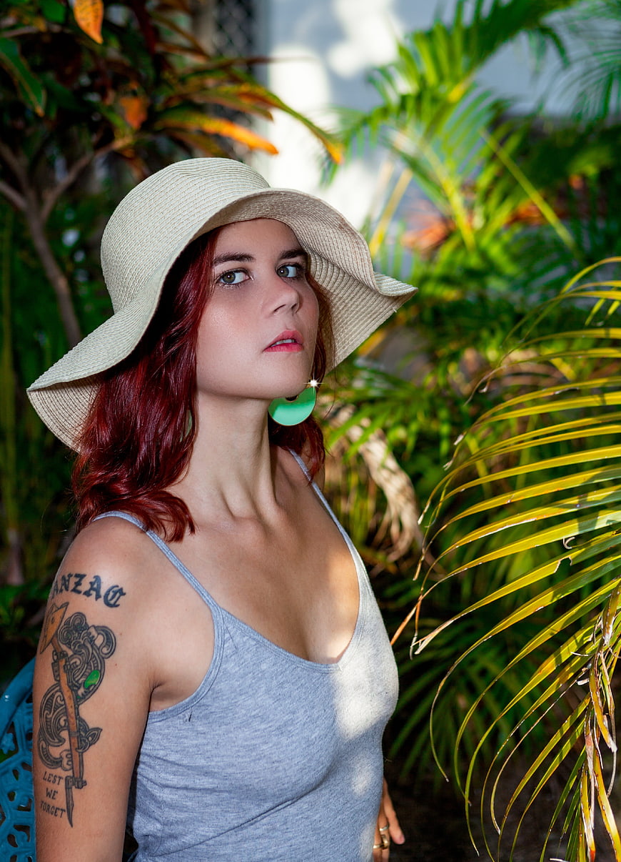 Woman with Red Hair and Straw Hat in Tropical Garden