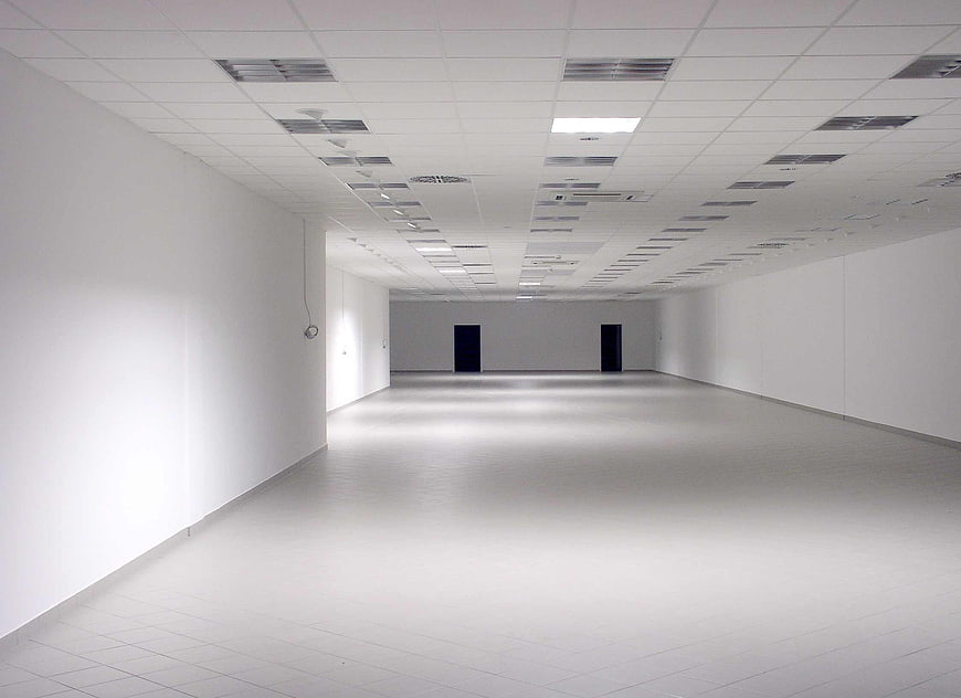 Empty white office interior with drop ceiling and tiled floor