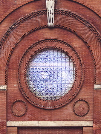 Red brick facade with circular glass block window and arch