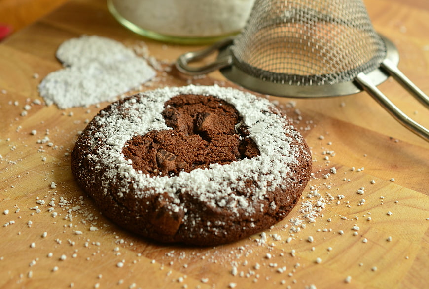 Chocolate cookie with heart-shaped powdered sugar dusting