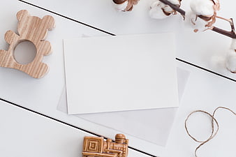 Minimalist flat lay with blank card, wooden toys, and cotton